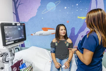 Pediatric cardiologist checks vital signs of her pediatric cardiology patient 
