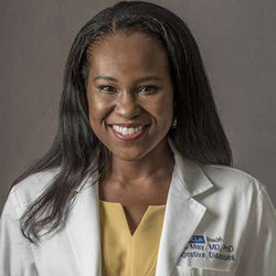 Headshot of Dr. Fola May in white coat