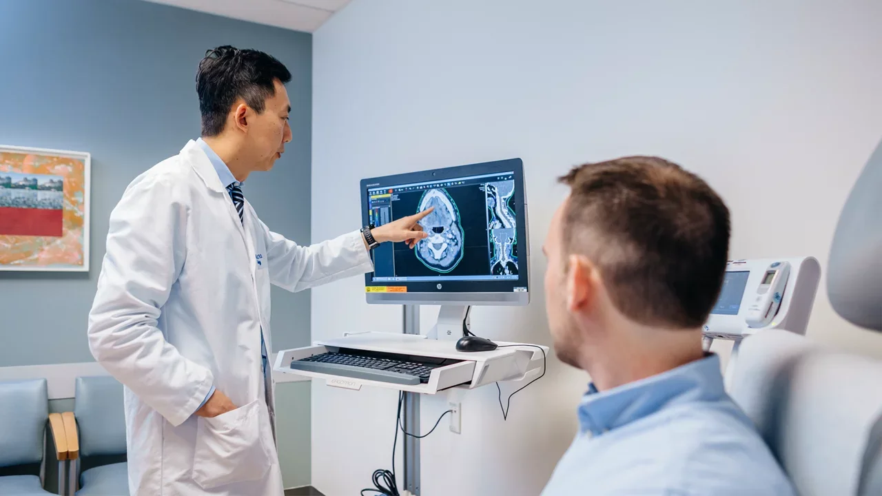 A physician-scientist explaining a procedure to a trial participant.