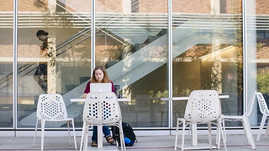 Student on laptop in Geffen Hall patio