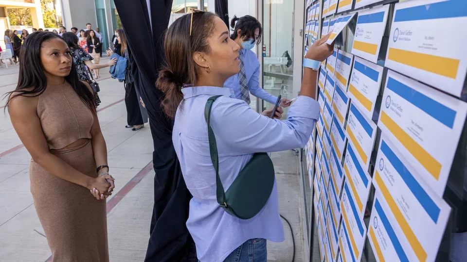 Eden Patton, left, looks on pensively as classmate Justine Seivright finds her Match Day envelope. 