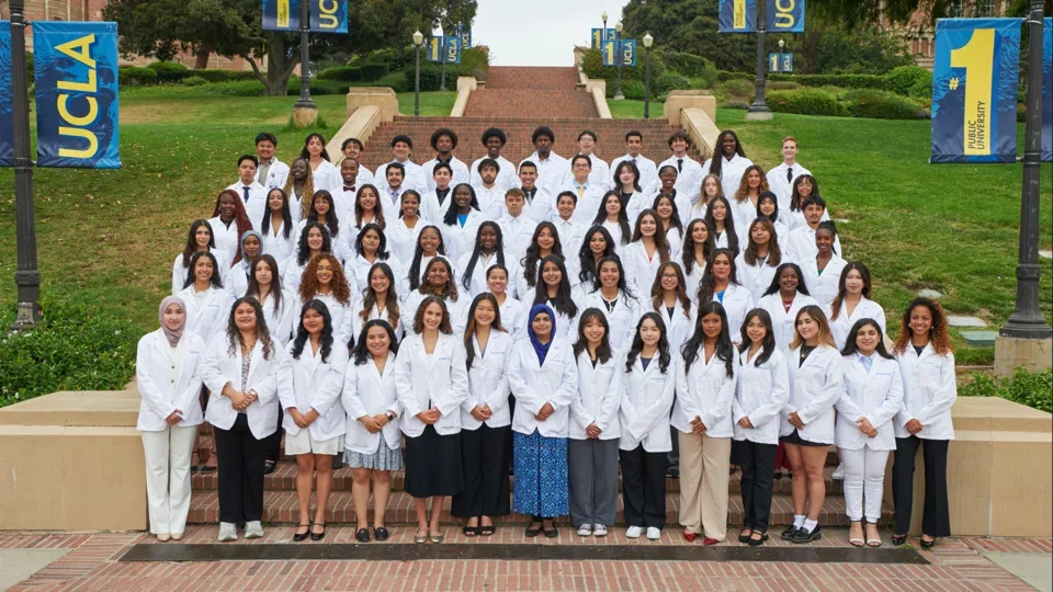 The 2025 cohort of SHPEP Scholars standing in their white coats on UCLA Janss Steps