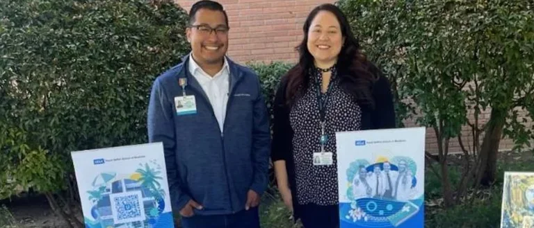 Two people smiling behind a booth.