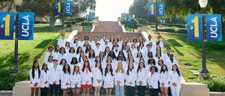 A photo of the 2024 cohort of SHPEP Scholars standing in their white coats on Janns Steps at UCLA.