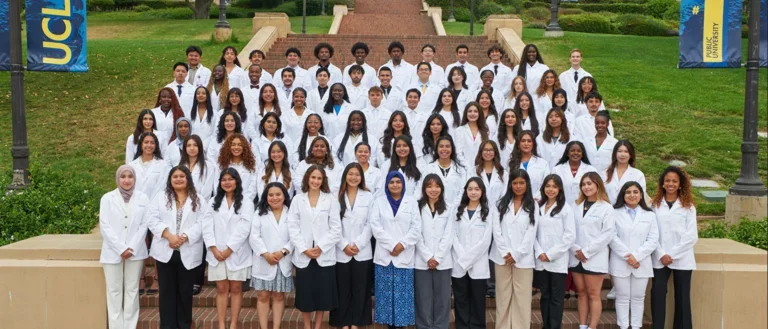 The 2025 cohort of SHPEP Scholars standing in their white coats on UCLA Janss Steps