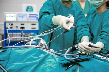 Physicians in scrubs performing a surgical procedure 