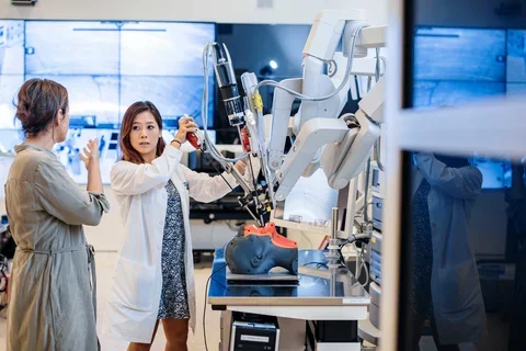 Faculty overseeing resident using equipment