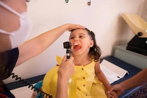  a girl in a yellow dress getting an exam