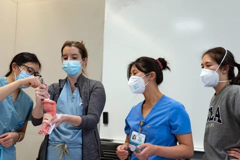 Med School Mentorship Program A group of medical students, all women, work on a problem together in a simulation lab