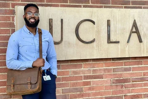 Dr. Igwe standing in front of a UCLA sign on campus