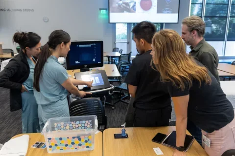 Students gathered around monitor at intro POCUS course 