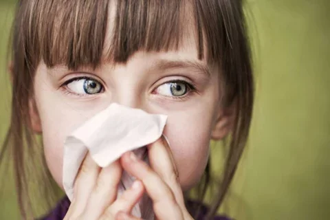 Young female with tissue over nose