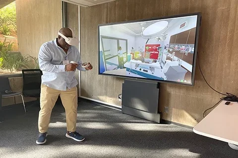 Alumnus testing out virtual reality learning system