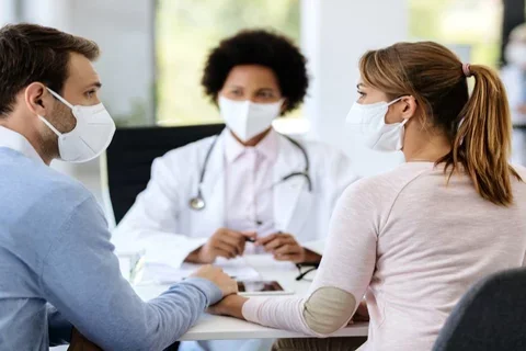 three adults wearing masks