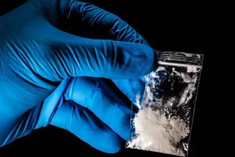 gloved hand holding medicine