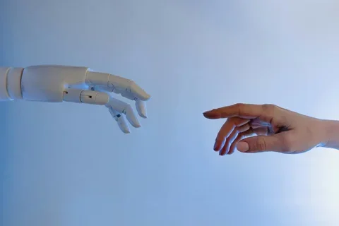 Robotic hand almost touching a human hand