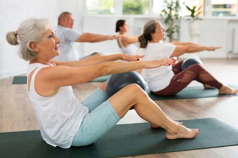 Individuals on mats completing yoga poses 