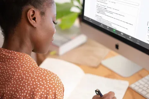 Pre-med student writing notes at computer