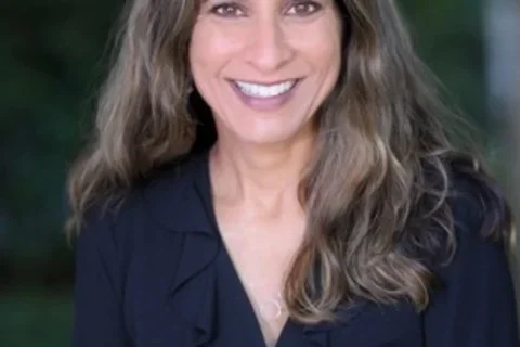 female physician smiling in black shirt