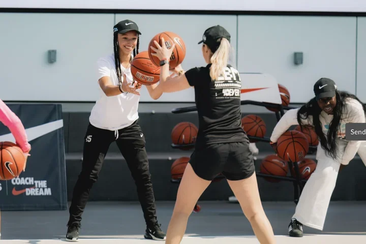 Two women passing basketball to each other