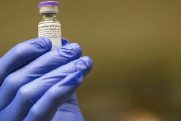 gloved hand holding vaccine