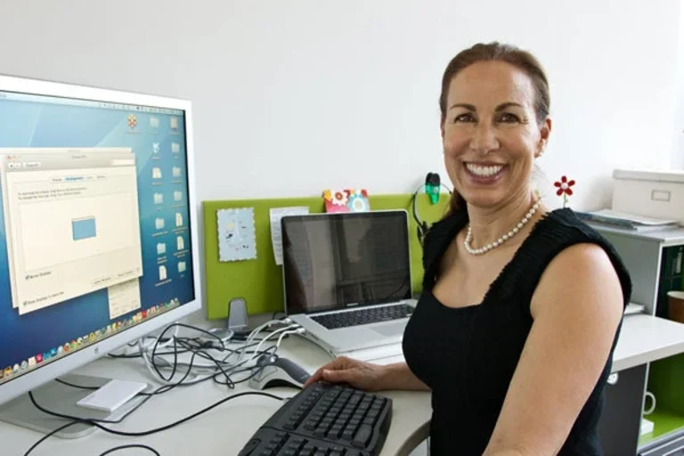 Marlene Berro sits in front of a computer monitor