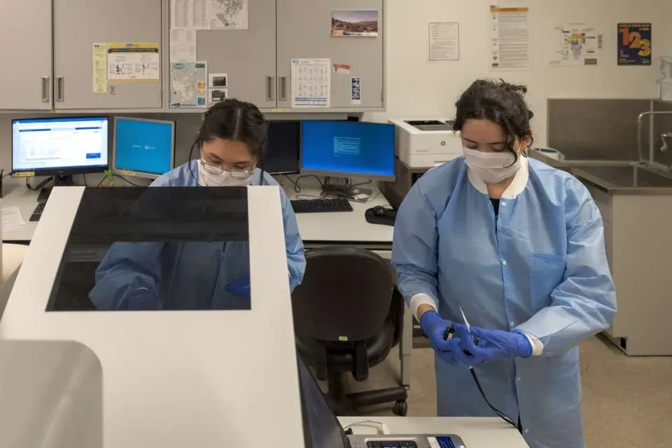 Lab assistants Theresa Denise Llera and Lynda Jauregui running tests in the Technology Center for Genomics &