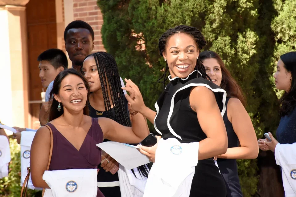 Two medical students high five at the White Coat Ceremony