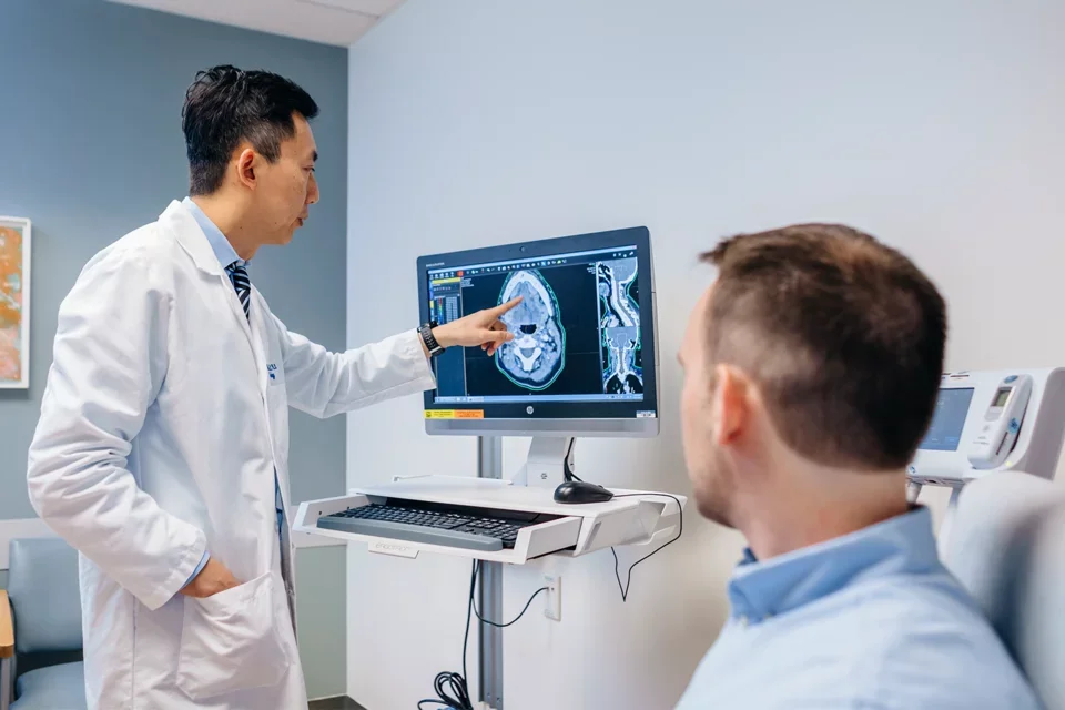 A physician-scientist explaining a procedure to a trial participant.