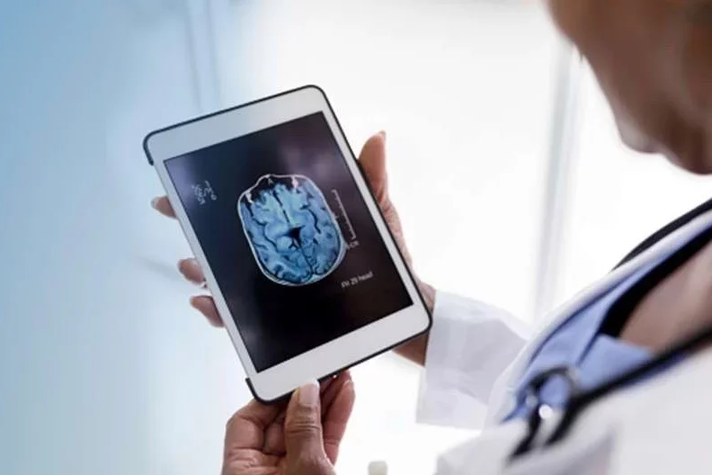 How Is Alzheimer's Diagnosed Doctor Looking at Brain Imaging on Tablet
