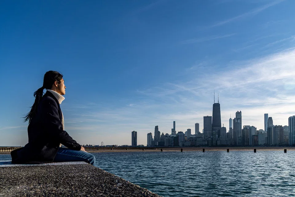 Xin Qi looks out over Boston Harbor