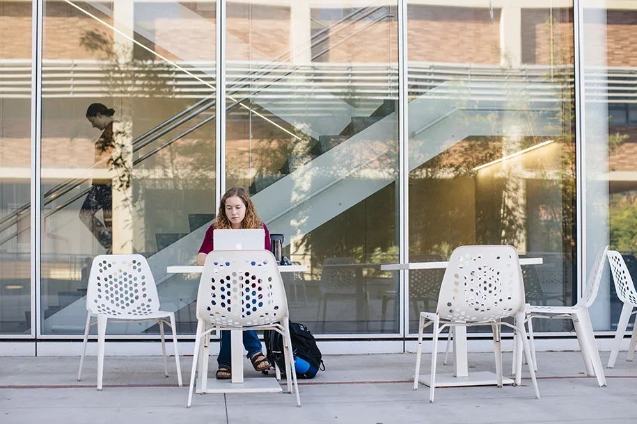 Student on laptop in Geffen Hall patio