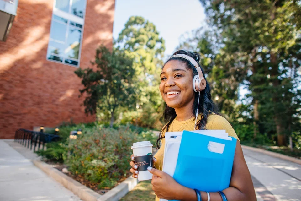 Medical student standing in front of Geffen Hall and the botanical gardens
