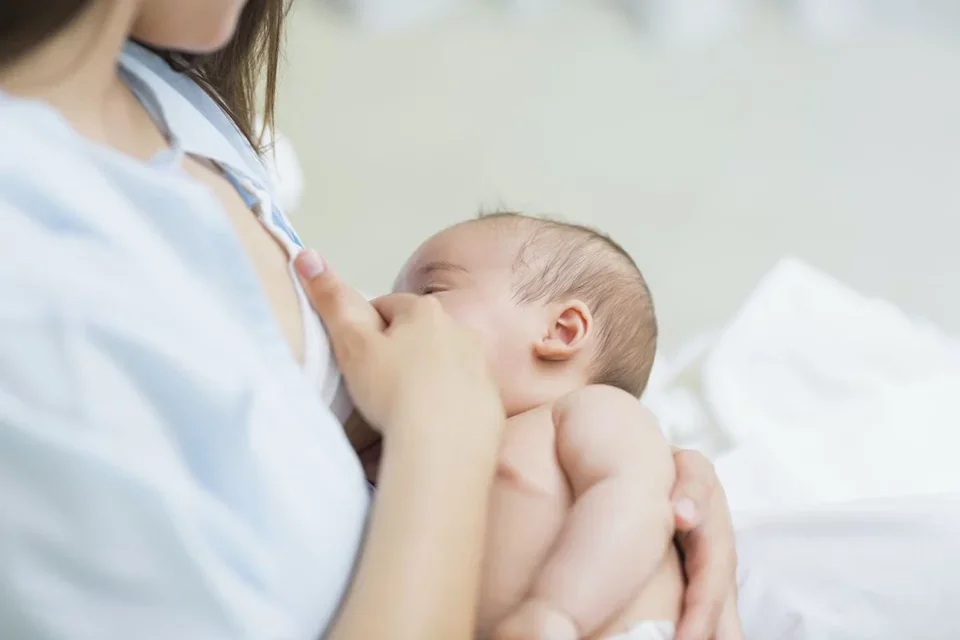 Mother breastfeeding her baby and overcoming common breastfeeding challenges