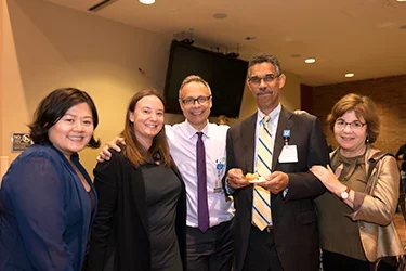 A group of people in a conference room embracing each other 