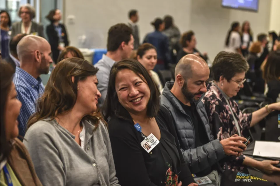 Staff members chat at an event in Geffen Hall