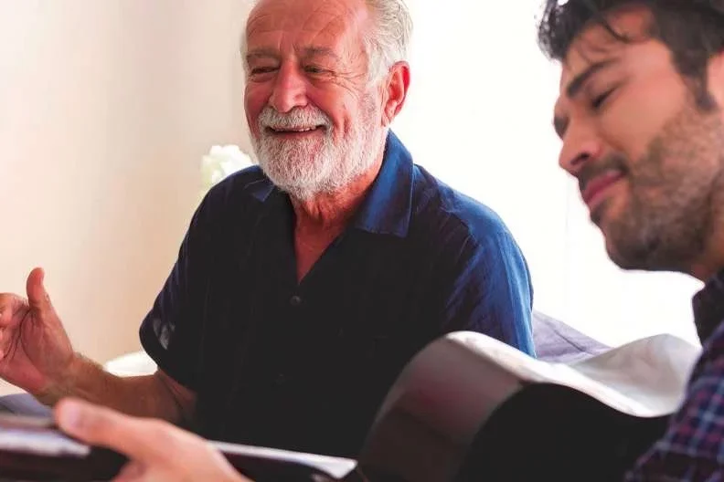 What Is Alzheimer's Senior Male Patient Enjoys Listening to Younger Male Companion Playing Guitar