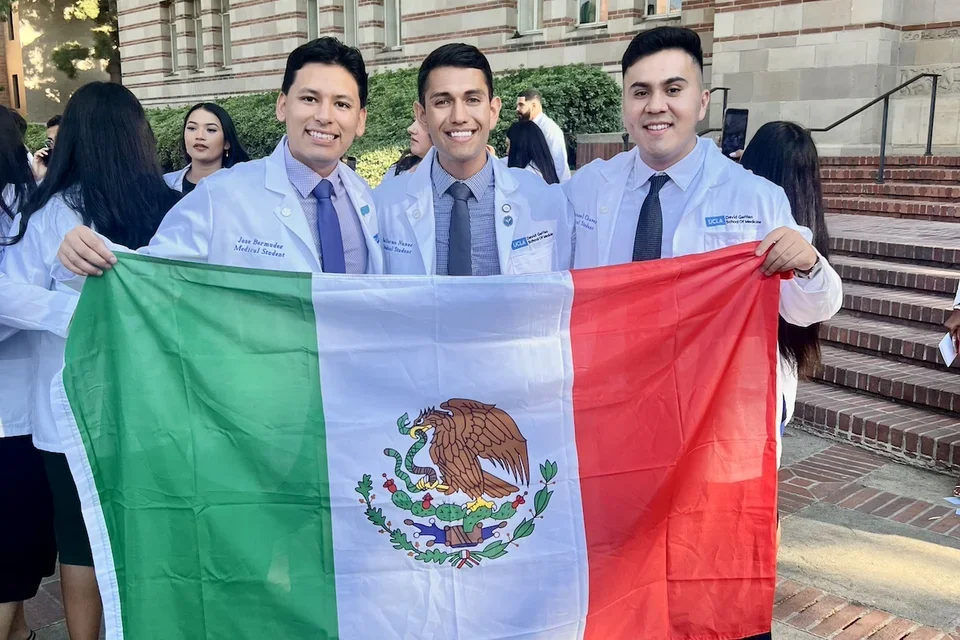 Jose and his fellow med students holding the Mexican flag