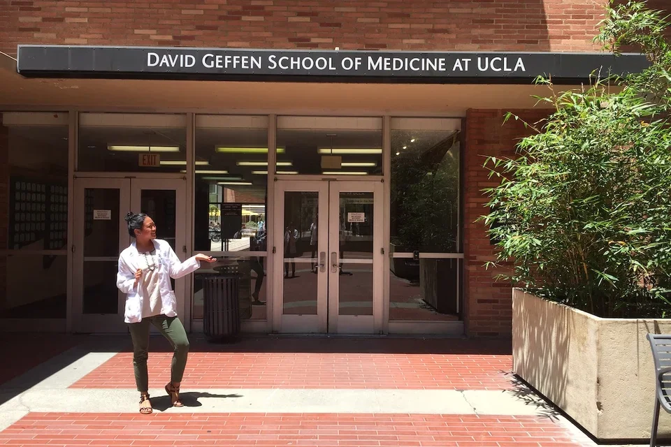 Medical student Melanie Ramirez, posing in front of a David Geffen School of Medicine sign