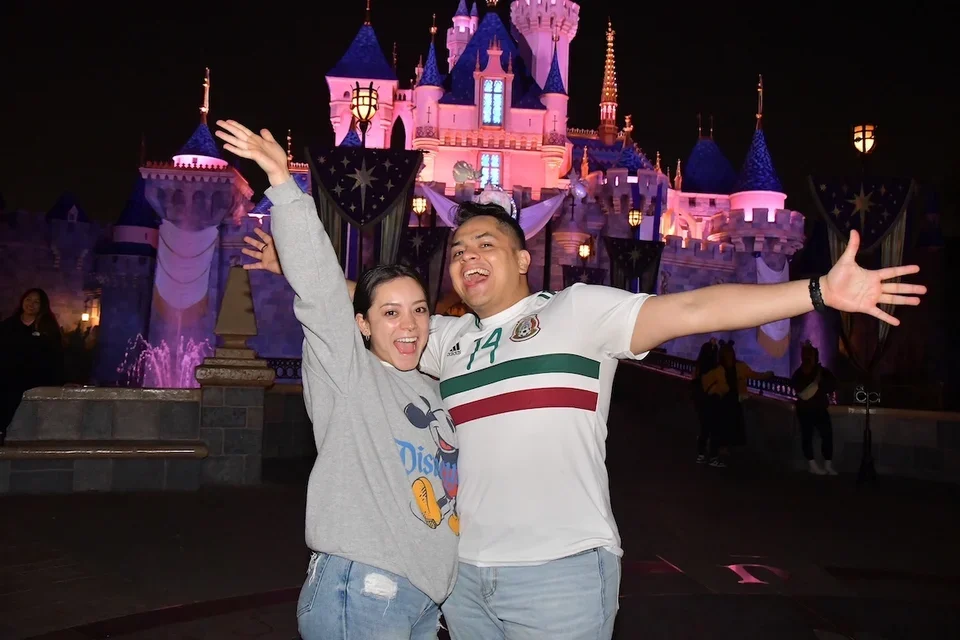 Darwin and Jennifer Gutierrez, DGSOM alumni who fell in loving during medical school, posing at Disneyland