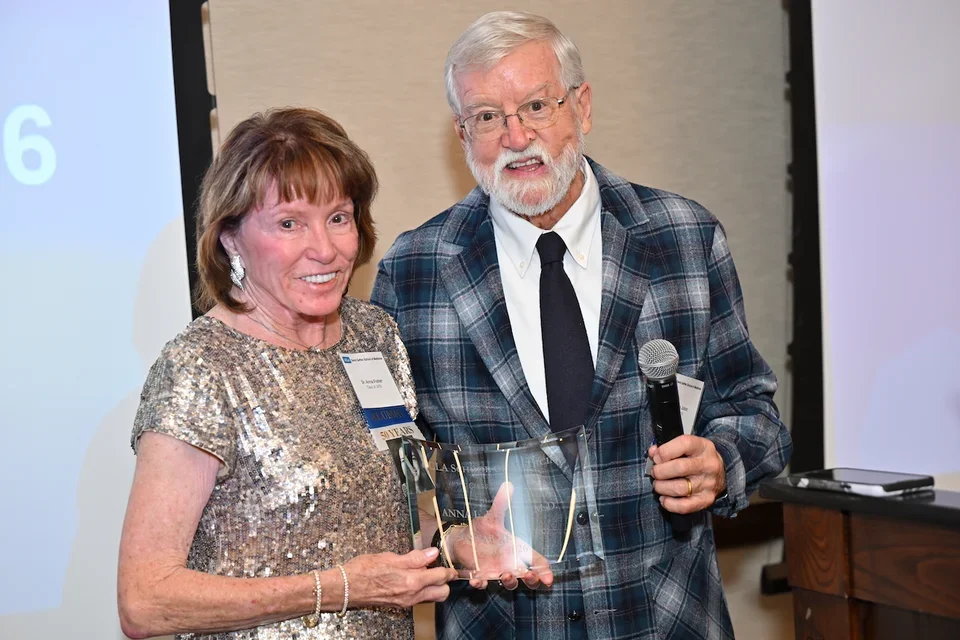 Alumna Anna Lee Fisher, MD stands with Steven Jobst, MD, the co-chair of the class reunion committee, to accept an honor from her class.