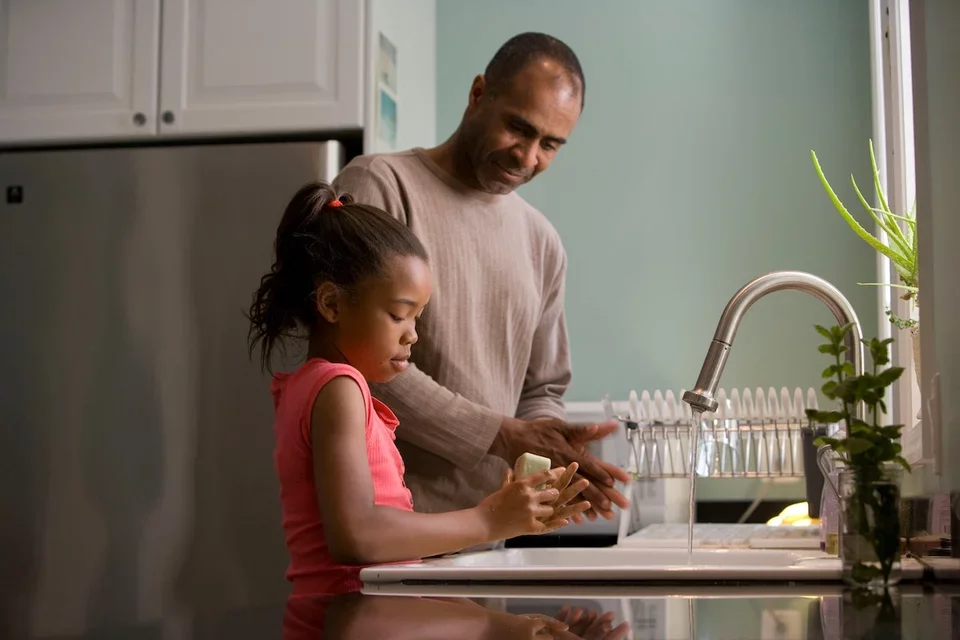 Man and child washing their hands 