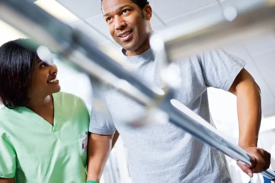 Physical Therapist Assisting Patient With Walking Exercises