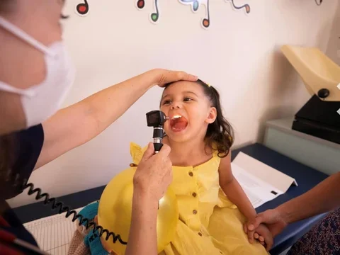  a girl in a yellow dress getting an exam