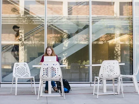 Student on laptop in Geffen Hall patio