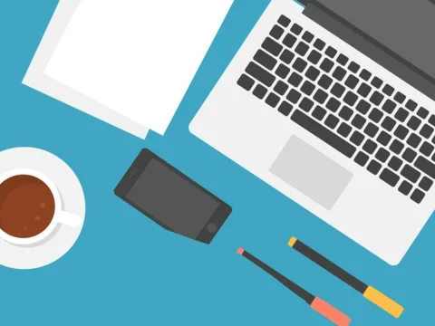 Open laptop and writing utensils, cup of coffee on a desk