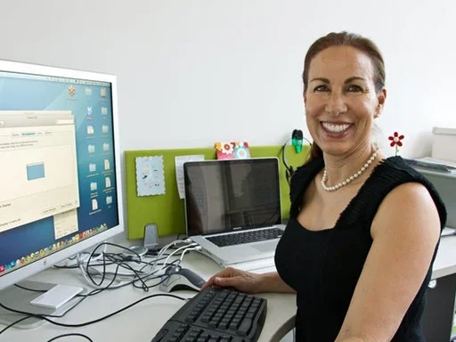 Marlene Berro sits in front of a computer monitor