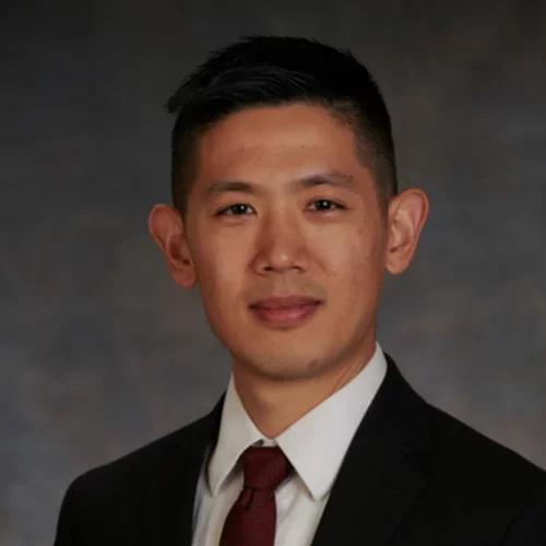 headshot of Dr. Cheng Quen in a black suit