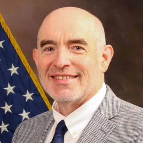 Steven Simon standing in front of a US flag