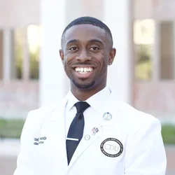 Medical student Samuel Edwards posing in his white coat